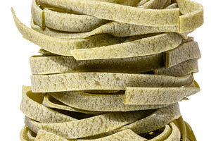Nest of dry green egg pasta tagliatelle with spinach, isolated b, a Food & Drink Photo by ndanko