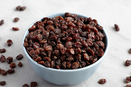 Dried Brown Raisins in a Bowl, side view., a Food & Drink Photo by LiudmylaChuhunova
