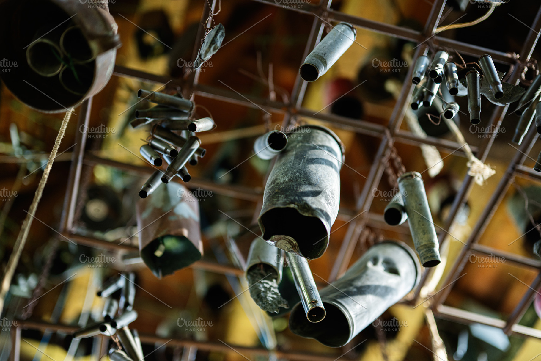 Various metal wind bullet chimes hanging artistically indoors under soft lighti, a Photo by AS photostudio