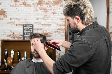 Man barber cutting hair of male client with clipper at barber shop. Hairstyling, a Person Photo by david.herraez.calzad