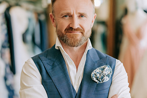 Middle aged man in blue vest and white shirt crossing arms, smil, a Person Photo by Studio ANNA