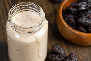 fresh cow's milk yogurt with prune flavor with dried plum slices, a Photo by rsoollAI