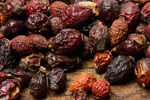 Dried rose hips on a wooden table, close-up.