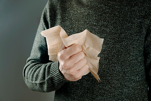a man firmly holding a recycled paper tissue, a Photo by Nito