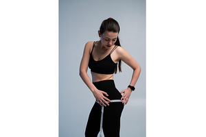 Young woman measuring hips with a, a Sports & Recreation Photo by volodymyrshtun13795