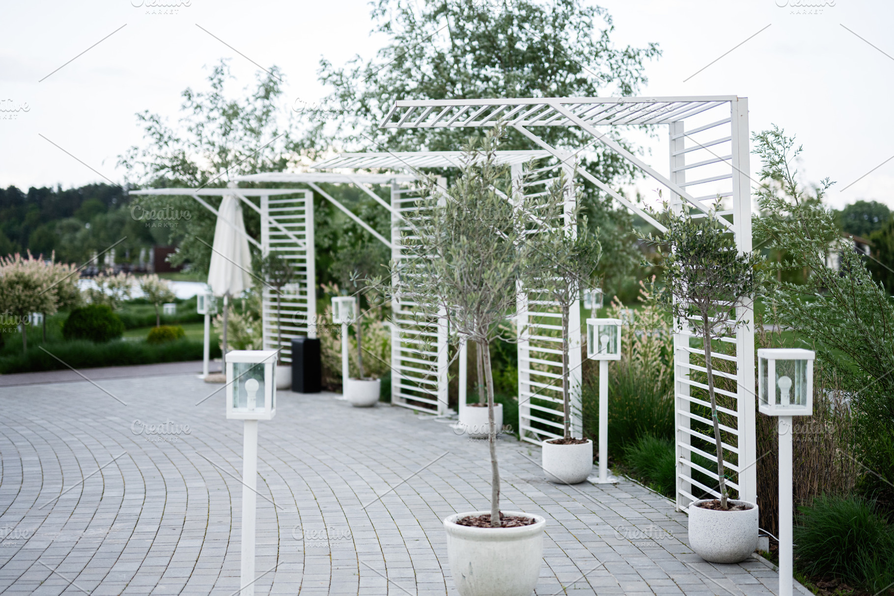 Modern garden setting with white pergolas, planters, and landscaping details, a Photo by AS photostudio