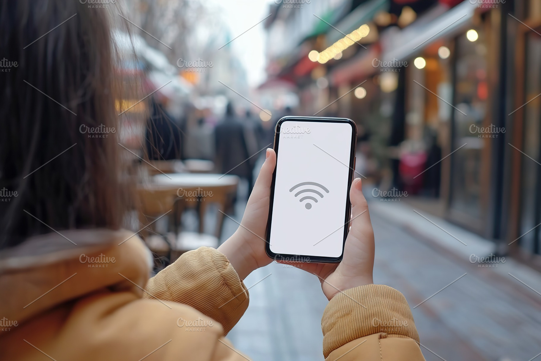 Hands holding a smartphone displaying a wifi symbol in a busy urban street, a Photo by AlyaAnd