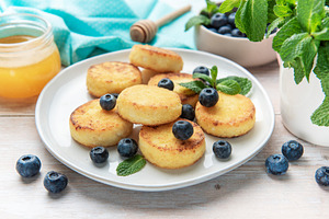 Syrniki curd pancakes with blueberries and honey for breakfast, a Food & Drink Photo by Olena Rudo