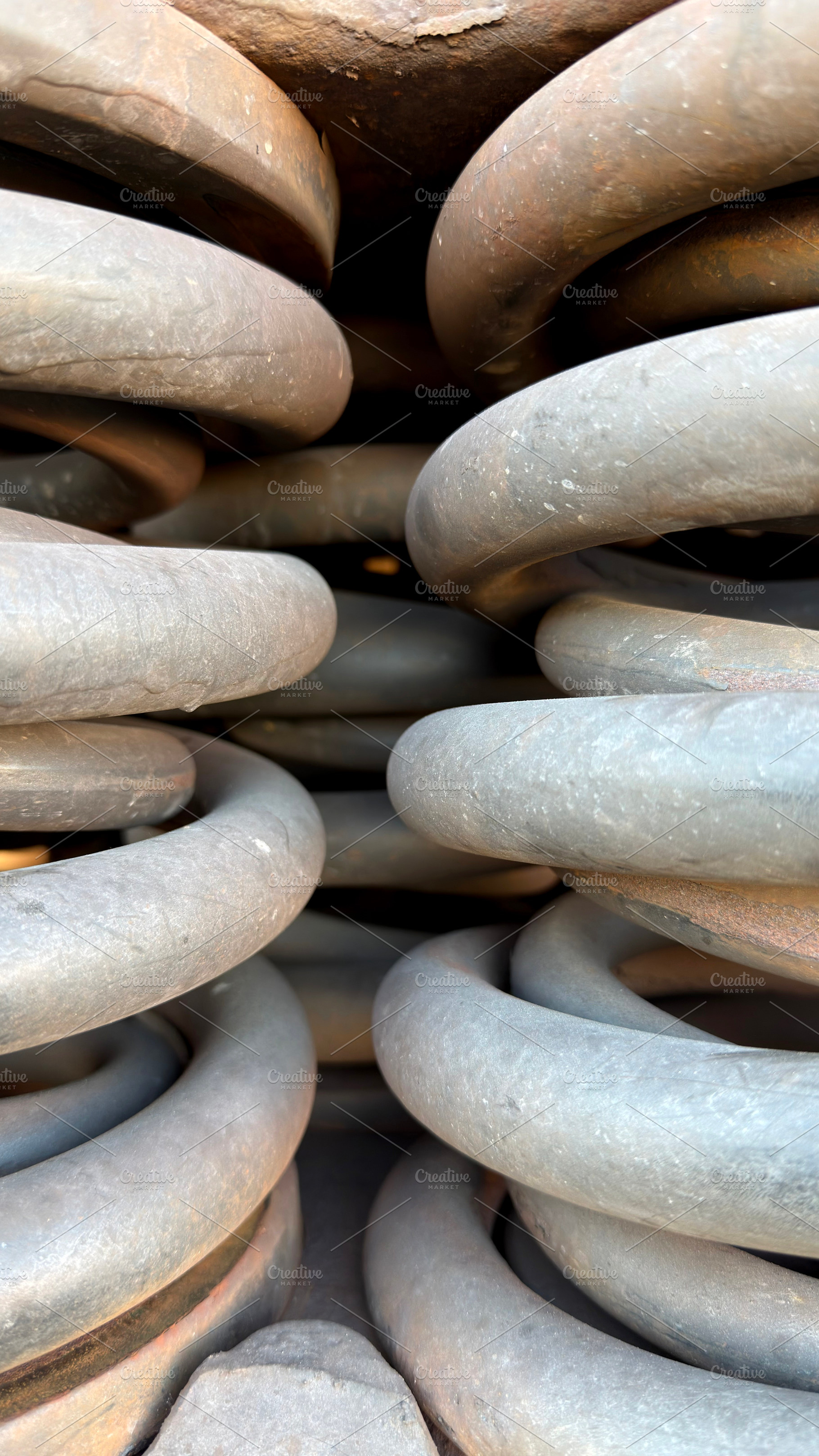 Close-up view of large metal springs stacked together, showcasing their coiled, an Industrial Photo by Textures & Backgrounds