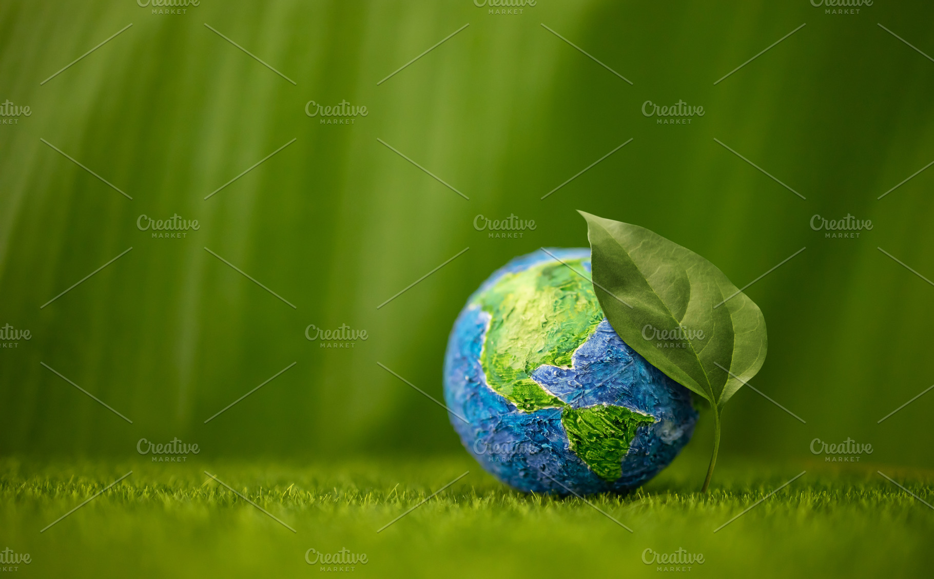 Globe with Green Leaf on Green Nature background. Environmental, a Photo by salmon.black