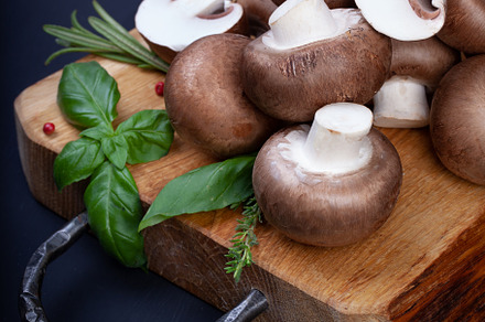 Fresh champignon mushrooms on wooden table