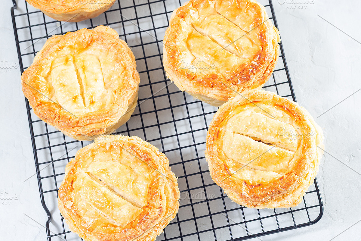Small beef pot pies on cooling rack, top view, square, a Food & Drink Photo by iuliia_n (Photo 2 of 2)