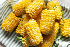 Fresh sweet corn cobs on striped cloth, a Food & Drink Photo by Olena Rudo