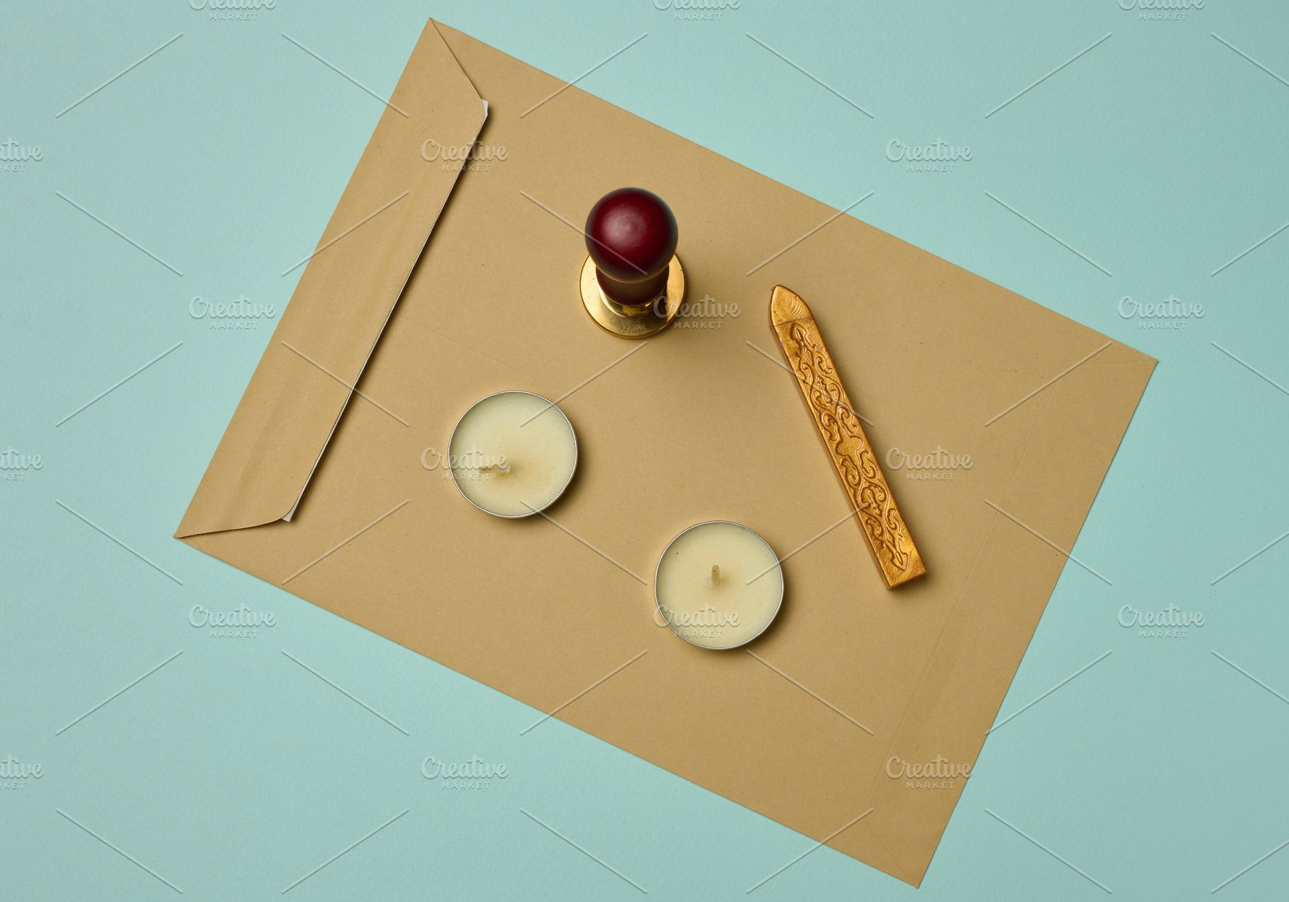 Craft envelope, wax seal, candles, and sealing wax stick on a tu, a Business Photo by ndanko