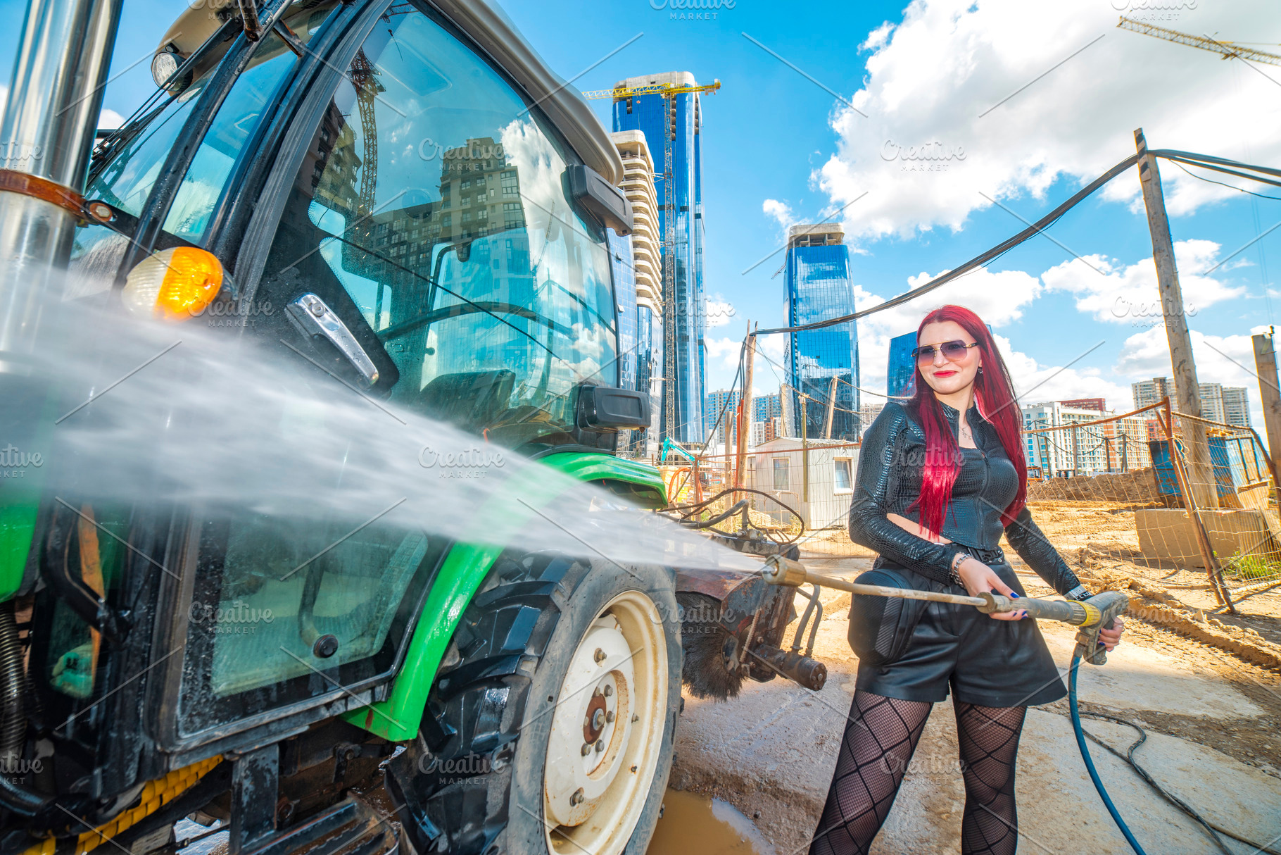 Red haired woman cleaning green tractor with pressure washer wit, a Photo by Pictures for you!!!!!!!!!