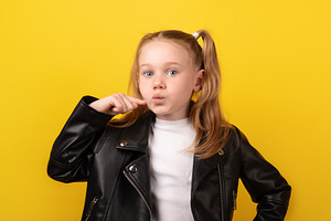 Young girl in black leather jacket pointing at her cheek while m, a Person Photo by Ales Munt