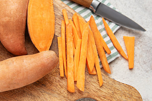 Preparing sweet potato fries on a wooden cutting board, a Food & Drink Photo by Olena Rudo