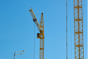 Two tall cranes stand in an urban, an Industrial Photo by darksoul72