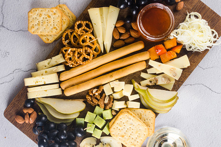 Delicious cheese mix with grapes, jam, snacks, crackers, walnuts, a Food & Drink Photo by vimart