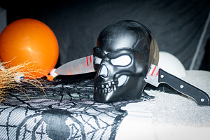Black skull with bloody knives as spooky Halloween party, a Person Photo by etorres69