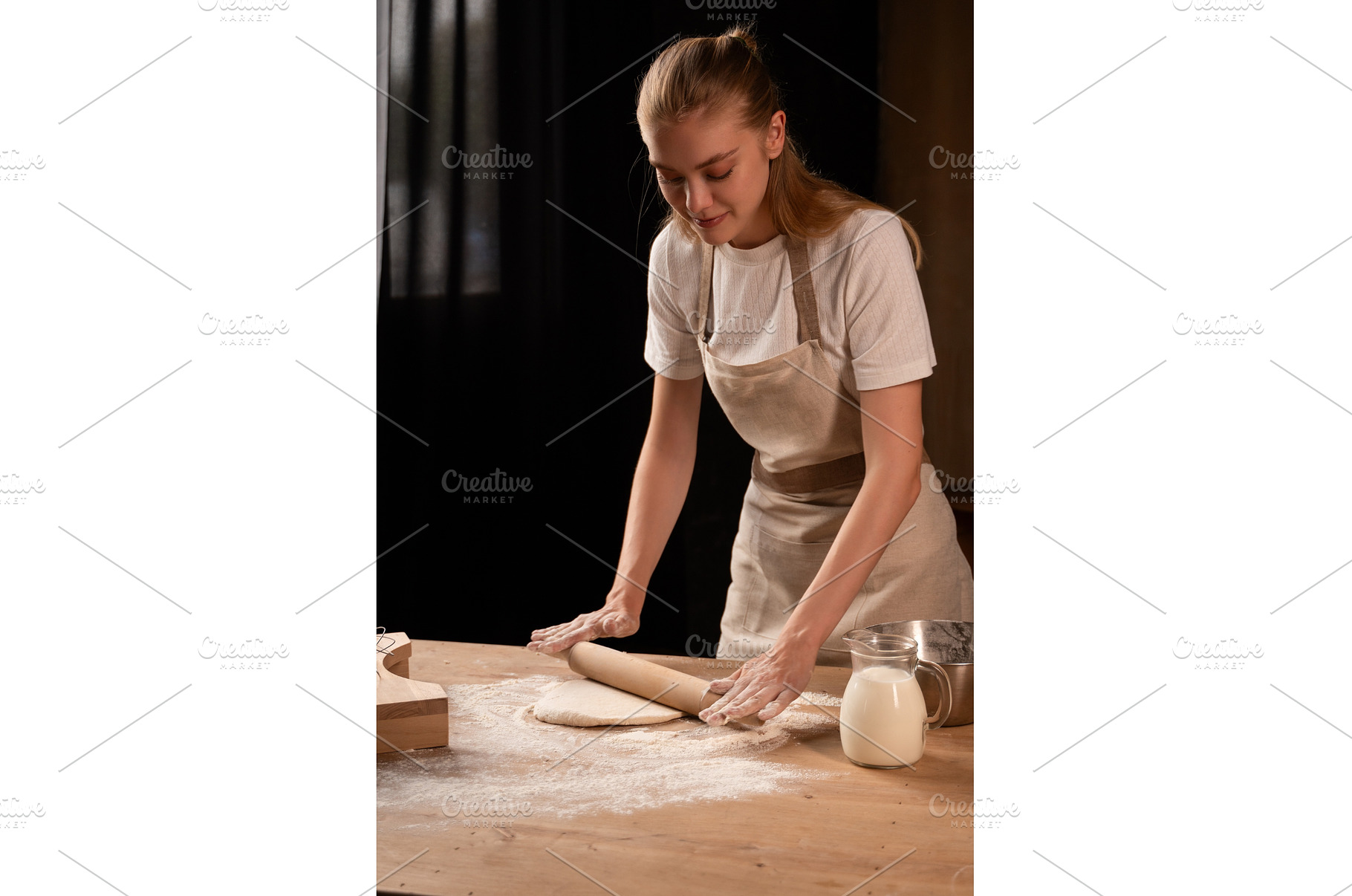 Young woman baking bread or pastry, a Food & Drink Photo by volodymyrshtun13795