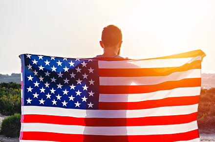 Rear view of man holding USA flag
