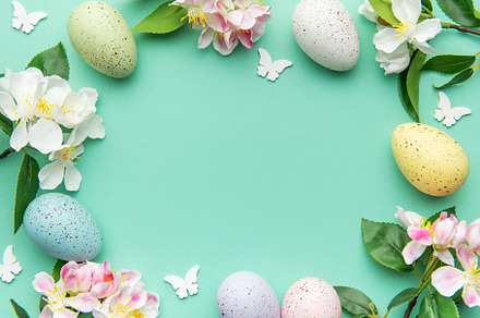 Easter eggs and spring flowers creating a frame on a turquoise b, a Holiday Photo by Olena Rudo