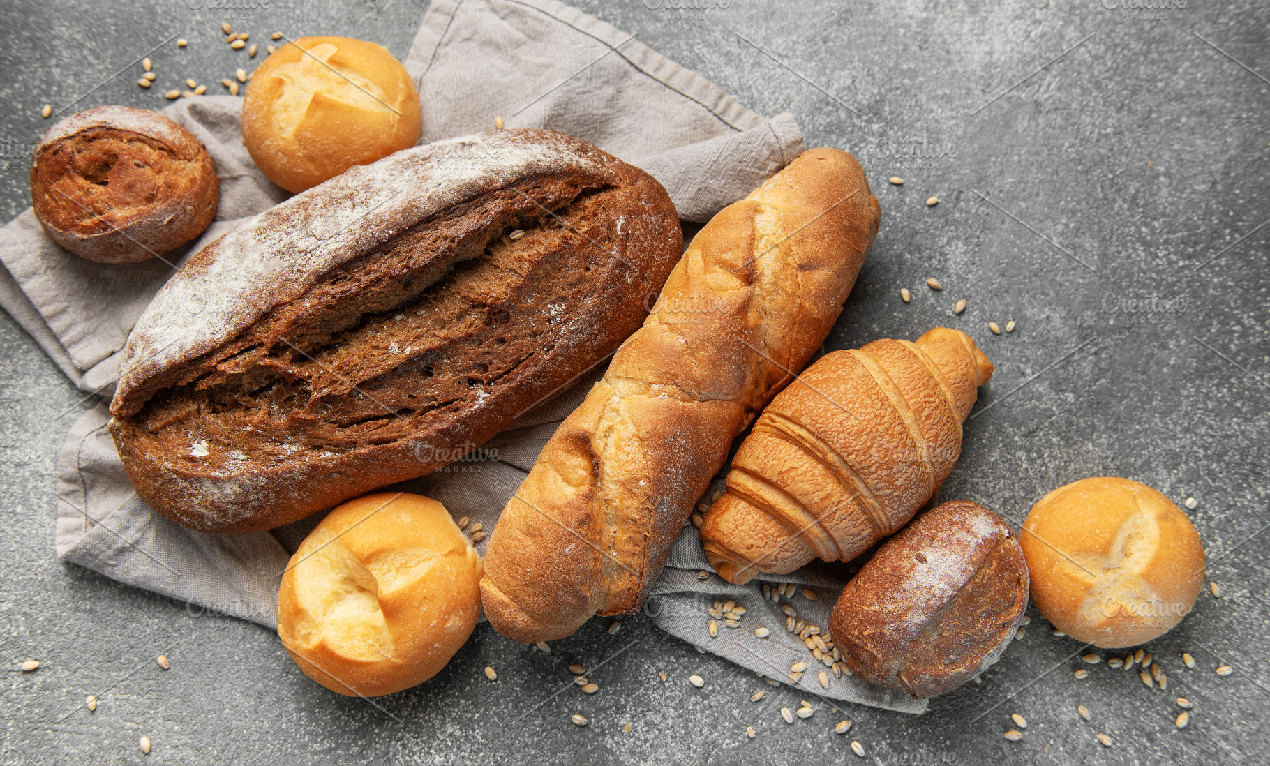 Freshly baked bread assortment on rustic grey background, a Food & Drink Photo by Olena Rudo