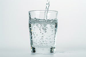 Pouring water into glass on white background, a Photo by AlyaAnd