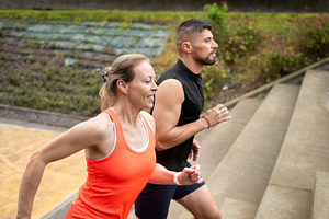 Personal trainer coaching mature woman running up stairs during outdoor workout, a Sports & Recreation Photo by etorres69