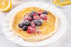 Lemon curd galette cake, with fresh berries, lemon zest and suga, a Food & Drink Photo by Rimma