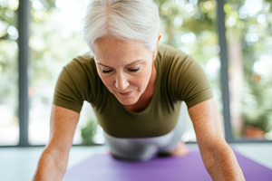 Middle-aged woman practicing yoga on, a Photo by Dvoevnore photos