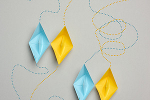 Blue and yellow paper boats sailing in pairs along dotted route, a Business Photo by ndanko