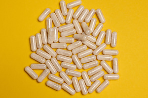 Pills in a capsule on a yellow background, pain treatment., a Health & Medical Photo by ndanko