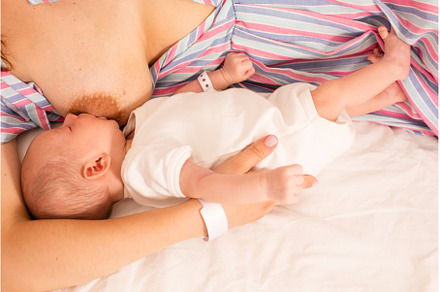 The mom is breastfeeding her newborn, a Health & Medical Photo by oksix