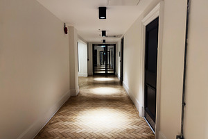 Quiet hotel hallway with warm lighting and mirrored end stretching into the dis, a Photo by AS photostudio