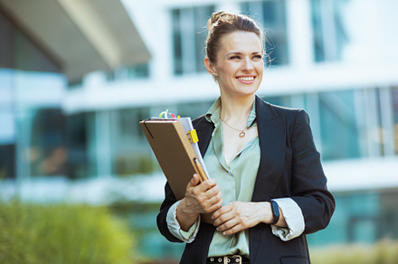 smiling modern woman worker in business district, a Business Photo by Alliance Images