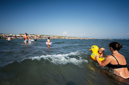 Mother and child enjoying a summer day at the beach with an inflatable duck, a Photo by AS photostudio