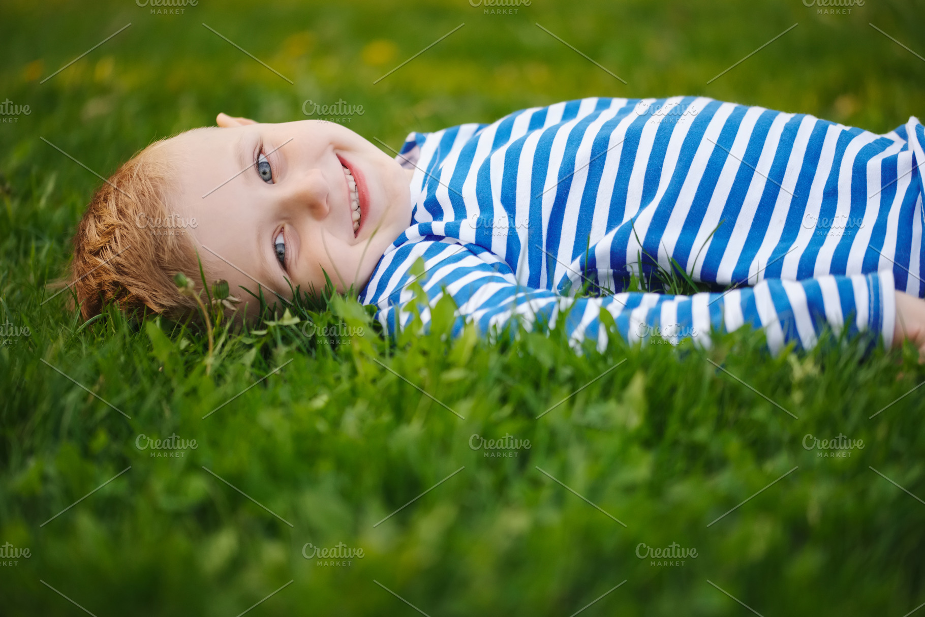Little boy lying on the grass containing green, grass, and boy, a Nature Photo by AlohaHawaii