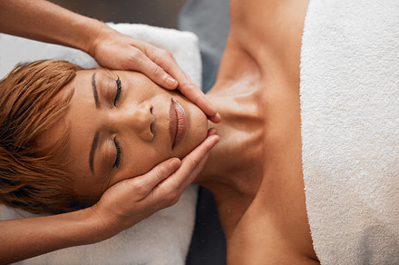 Top view, hands and facial massage at spa for beauty, treatment or relax. Face, skincare and wellness of black woman at peace relaxing, release stress or tension with eyes closed at luxury resort., a Photo by Peopleimages.com