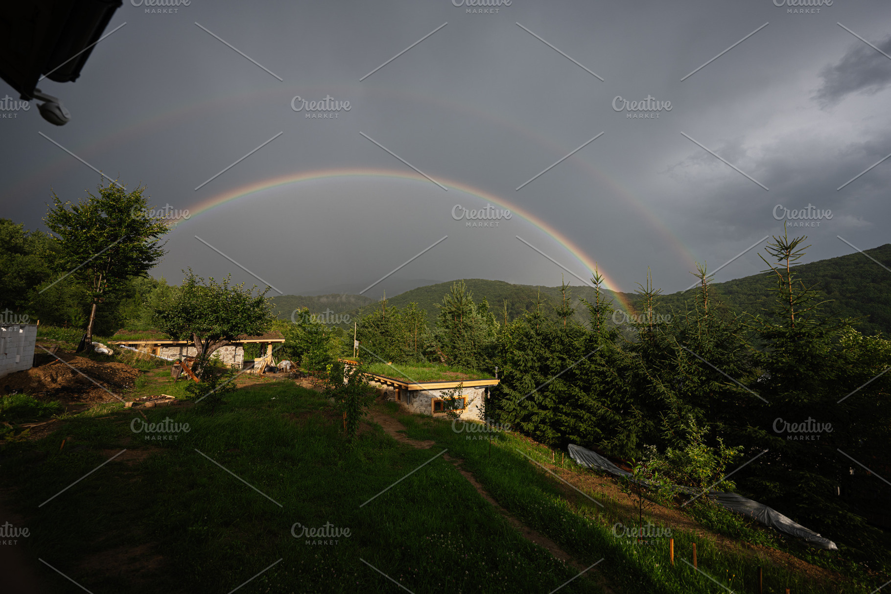 Scenic view of double rainbow over green landscape and cloudy sky, a Photo by AS photostudio