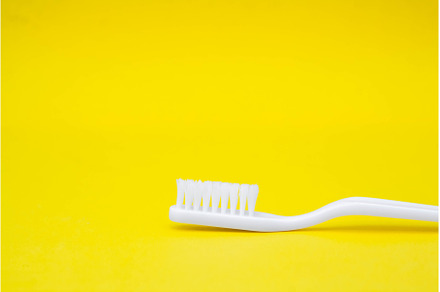 White toothbrush on yellow, a Health & Medical Photo by olhovyi_photographer