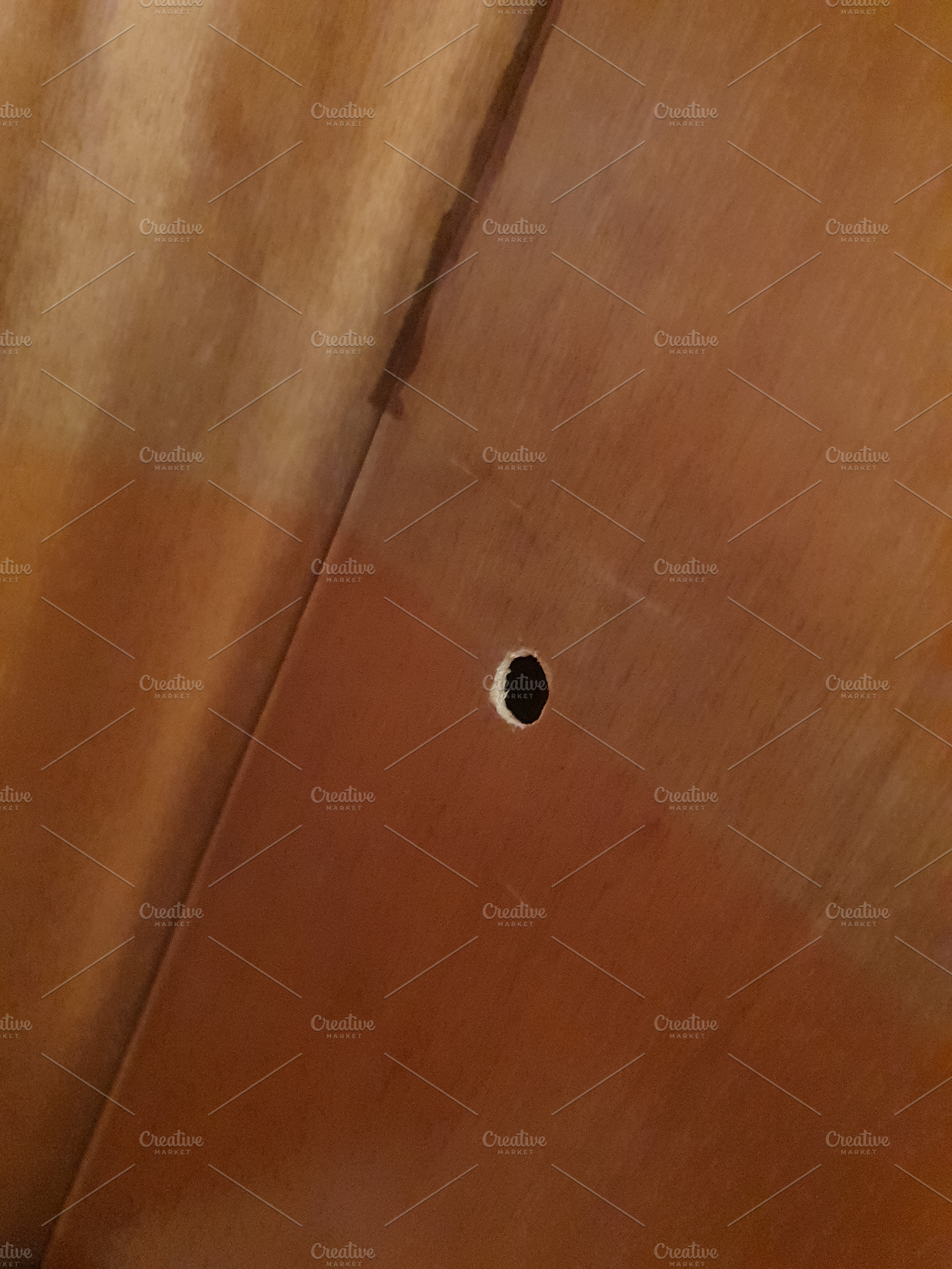 hole in plywood sheet, a Photo by WorldOfPhotos