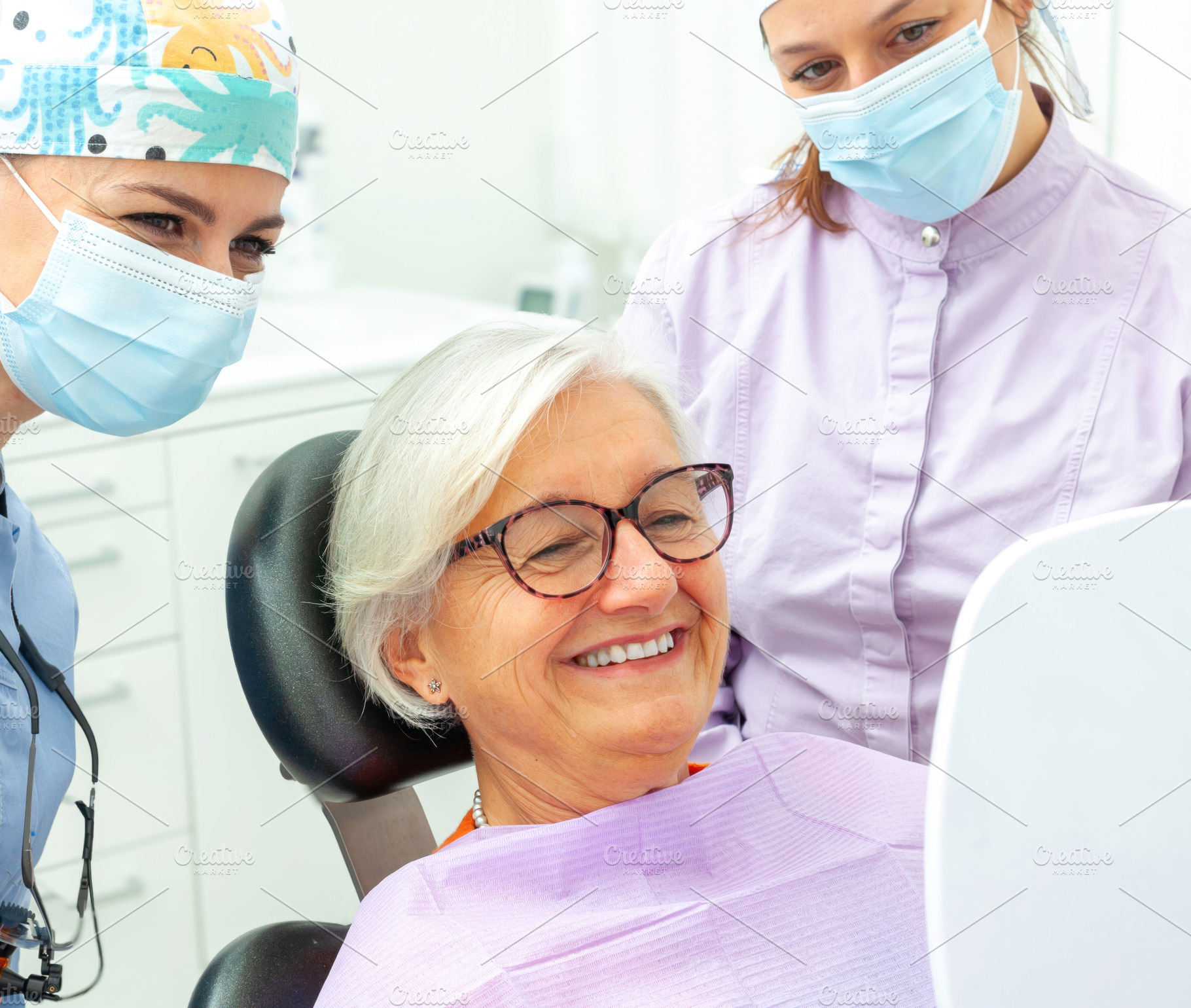 Senior woman admiring her new smile after dental procedure, a Photo by Antonio Gravante Market