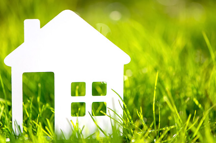 Paper house against on green grass.
