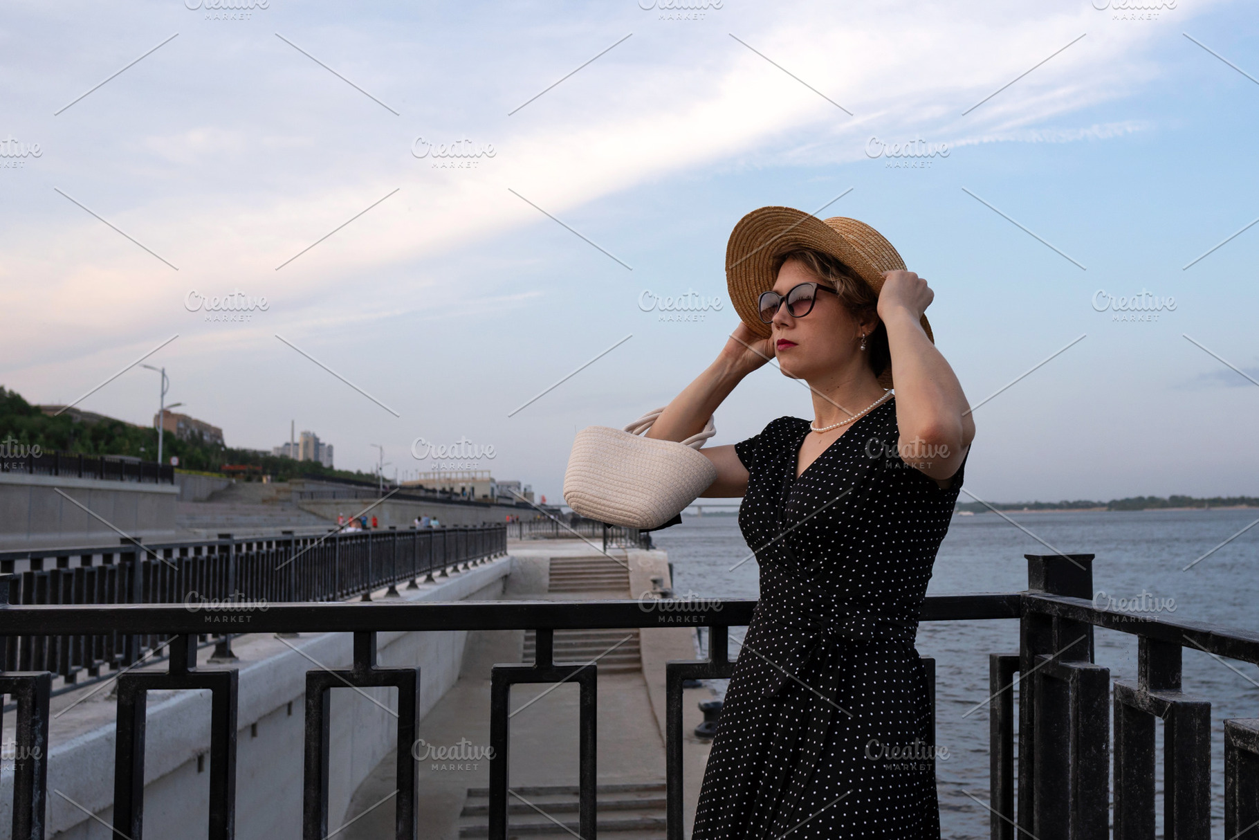 Woman adjusts straw hat, a Person Photo by Elena Vagengeim