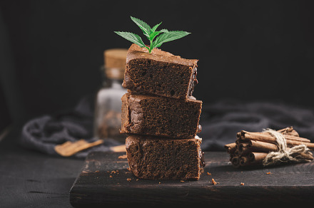 Baked pieces of chocolate brownie pie on black table, delicious, a Food & Drink Photo by ndanko