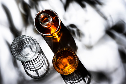 Whiskey in glasses and bottle, white background with hard light,, a Food & Drink Photo by 5PH