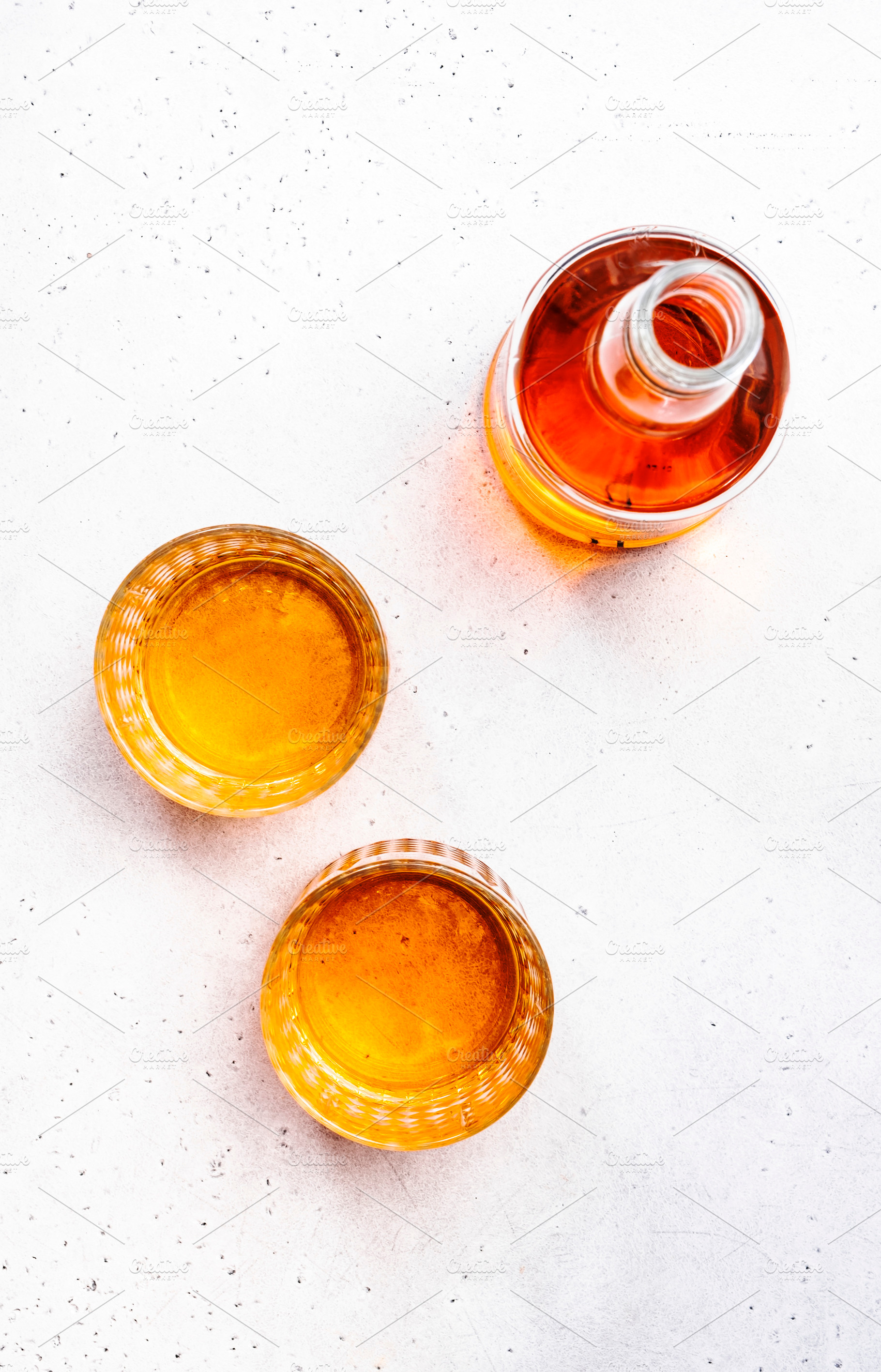 Scotch Whiskey glasses and bottle on white table background, cop, a Food & Drink Photo by 5PH