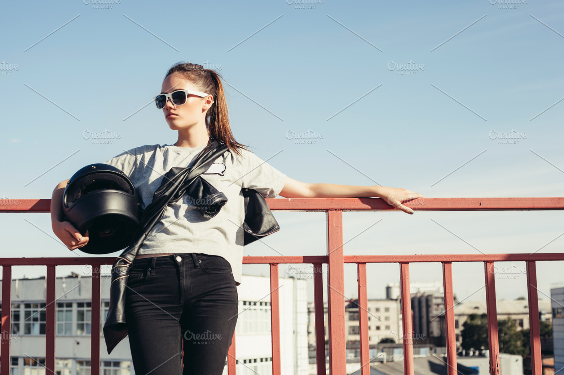 Young female biker holding motorcycle helmet stock photo containing girl and, a Person Photo by Aliaksei Kaponia